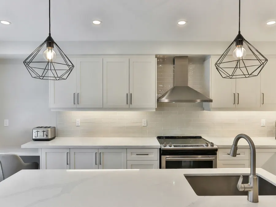 White shaker kitchen with a quartz island and pendant lighting